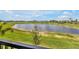 Picturesque view of the backyard featuring a serene lake, lush greenery, and a bright blue sky at 43250 Water Bird Way # 5921, Punta Gorda, FL 33982