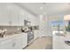 Clean kitchen featuring white cabinets, stainless steel appliances, and a kitchen island with a stainless steel sink at 43250 Water Bird Way # 5921, Punta Gorda, FL 33982