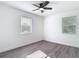 Well-lit bedroom with wood-look flooring, windows and ceiling fan at 485 Stillwater Ave, Spring Hill, FL 34606