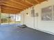 View of a carport with concrete flooring, attached to the home's exterior with access to a side door at 485 Stillwater Ave, Spring Hill, FL 34606