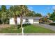 Charming single-story home with white exterior, green lawn, and tropical palm trees at 485 Stillwater Ave, Spring Hill, FL 34606
