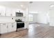 Bright, open kitchen with stainless steel appliances, white cabinets, and wood-look floors at 485 Stillwater Ave, Spring Hill, FL 34606