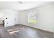 Open living room with wood-look floors, and a view to the kitchen at 485 Stillwater Ave, Spring Hill, FL 34606