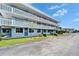 Side view of a light blue building exterior, surrounded by green grass and palm trees at 4895 Bay Ne St # 207, St Petersburg, FL 33703