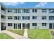 The rear exterior of a condo building with patios, sliding glass doors and green space at 4895 Bay Ne St # 207, St Petersburg, FL 33703