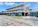 Exterior of condo building featuring stone accents, covered parking entrance and tidy landscaping at 4895 Bay Ne St # 207, St Petersburg, FL 33703