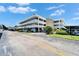 Exterior of the building with white balconies, mature landscaping, and covered parking at 4895 Bay Ne St # 207, St Petersburg, FL 33703