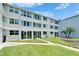 Back of a well-maintained condo building with patios, sliding glass doors and green space at 4895 Bay Ne St # 207, St Petersburg, FL 33703