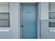 A close-up view of a blue front door, number 207, set within a light blue facade at 4895 Bay Ne St # 207, St Petersburg, FL 33703