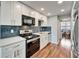 Modern kitchen boasts stainless appliances, white cabinets, quartz counters, and eye-catching subway tile backsplash at 4895 Bay Ne St # 207, St Petersburg, FL 33703