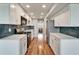 Galley kitchen features stainless appliances, white cabinets, quartz counters, and gray subway tile backsplash at 4895 Bay Ne St # 207, St Petersburg, FL 33703