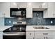Close-up view of a modern kitchen featuring stainless appliances, white cabinets, quartz counters, and subway tile backsplash at 4895 Bay Ne St # 207, St Petersburg, FL 33703