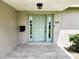 Close-up of the front door with light-green paint, sidelights and tile flooring at 5101 Dover Ne St, St Petersburg, FL 33703