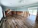 Open-concept living room with new tile flooring, exposed framing, and view of the staircase at 5101 Dover Ne St, St Petersburg, FL 33703