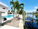 Beautiful canal-front home featuring a modern pool, dock and lift, surrounded by lush tropical landscaping at 5101 Dover Ne St, St Petersburg, FL 33703