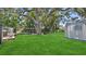 Expansive backyard featuring a green lawn, mature trees, and a storage shed at 5119 23Rd S Ave, Gulfport, FL 33707