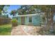 Turquoise house featuring a yellow door and pathway leading to the entrance, nestled among greenery at 5119 23Rd S Ave, Gulfport, FL 33707
