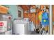 Utility area with a washer, dryer, water heater, storage shelves and assorted bins at 5119 23Rd S Ave, Gulfport, FL 33707