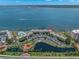 Aerial view of condo complex, pool, parking, gardens, and waterfront with boat; unit marked with red arrow at 5153 Isla Key S Blvd # 415, St Petersburg, FL 33715