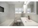 Bright bathroom features a sink vanity, a toilet, and large bathtub with marble tile walls at 520 34Th N Ave, St Petersburg, FL 33704