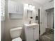 Bright bathroom features a sink vanity with storage, a toilet, and open doorway to an adjacent space at 520 34Th N Ave, St Petersburg, FL 33704