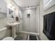 Bathroom features a white pedestal sink, decorative mirror, and tiled glass-enclosed shower at 520 34Th N Ave, St Petersburg, FL 33704