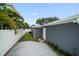 The exterior wall of the gray garage has grass on one side and a concrete sidewalk on the other at 520 34Th N Ave, St Petersburg, FL 33704