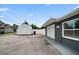 Gray garage with shed, blue bins, a gravel driveway, and green foliage in the background at 520 34Th N Ave, St Petersburg, FL 33704