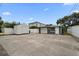 The dark gray garage has a white garage door, a side shed, and a gravel driveway at 520 34Th N Ave, St Petersburg, FL 33704
