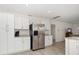 Bright kitchen features stainless steel refrigerator, white cabinets, and granite countertops at 520 34Th N Ave, St Petersburg, FL 33704