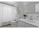 Clean bathroom with a shower curtain, decorative coral art, tiled walls, and a white sink with a plant at 529 59Th S Way, St Petersburg, FL 33707