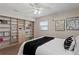 Bedroom showcasing wall shelving units, light walls, a bed, modern décor, and two windows at 529 59Th S Way, St Petersburg, FL 33707