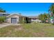 A single story home featuring a gray garage and palm trees lining the well manicured yard at 529 59Th S Way, St Petersburg, FL 33707