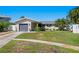 A single story home with a gray garage door, and palm trees lining the yard at 529 59Th S Way, St Petersburg, FL 33707