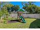 Backyard with a wooden playset, swings, a slide, and space for to play under the shade of trees at 529 59Th S Way, St Petersburg, FL 33707
