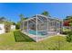 An exterior of a screened-in pool surrounded by a green lawn and bushes at 529 59Th S Way, St Petersburg, FL 33707