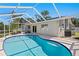 Screened-in pool area featuring a sparkling blue pool, surrounded by a concrete deck at 529 59Th S Way, St Petersburg, FL 33707