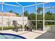 Screened-in pool area with two patio chairs offering a relaxed outdoor living space with lush greenery at 529 59Th S Way, St Petersburg, FL 33707
