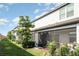 Backyard view showing screened in back porches, landscaping, and a lush green lawn at 5519 Tripoli Dr, Palmetto, FL 34221