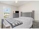 Bright bedroom featuring a gray bed with plaid bedding, window views, and modern decor and matching bedside tables at 5519 Tripoli Dr, Palmetto, FL 34221