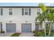 Townhome garages with manicured landscaping and charming exterior lighting at 5519 Tripoli Dr, Palmetto, FL 34221
