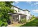 Back of the house with screened in porches and mature plantings against a bright blue sky at 5519 Tripoli Dr, Palmetto, FL 34221