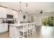 An open view of the kitchen with an island, barstool seating that extends into the living room area with tile flooring at 5519 Tripoli Dr, Palmetto, FL 34221