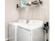 Laundry room featuring a white washer and dryer set, plus wire shelving and a wall-mounted vacuum cleaner at 5519 Tripoli Dr, Palmetto, FL 34221