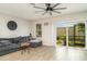 Bright living room featuring a comfortable gray couch, ceiling fan, tile floors, and a sliding door to the outside at 5519 Tripoli Dr, Palmetto, FL 34221