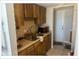 Compact kitchen featuring wood cabinets, a stainless steel sink and brick wall at 5541 Bay Blvd # 405, Port Richey, FL 34668