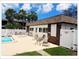 Community swimming pool next to clubhouse with outdoor seating and surrounding palm trees at 5541 Bay Blvd # 405, Port Richey, FL 34668