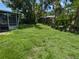 Lush green backyard featuring mature trees, native landscaping, and a screened porch at 5630 47Th N Ave, Kenneth City, FL 33709