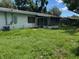 Large backyard showcasing green grass, the back of the house, and screen porch at 5630 47Th N Ave, Kenneth City, FL 33709
