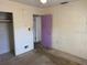 Bedroom with plain walls, neutral lighting, and an interior purple door at 5630 47Th N Ave, Kenneth City, FL 33709